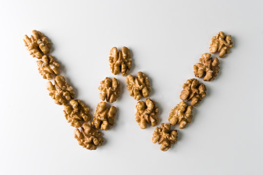 Walnut placed in a form of letter W. Creative designer concept. Nuts as food.