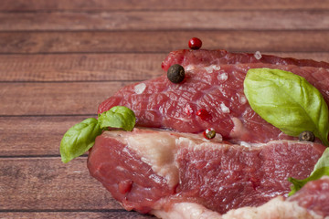 A piece of red raw beef meat on wooden cutting Board Dark background