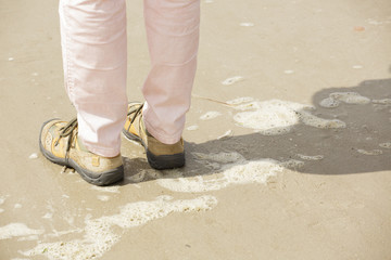 beine und füße mit schuhen am strand