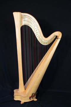 Harp musical instrument, isolated on a black background, vertically with copy space