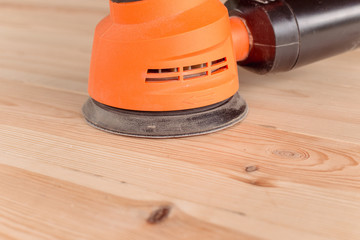 closeup of the orbital sander on a wooden table