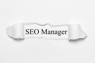 Obraz premium SEO Manager on white torn paper