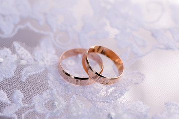 Obraz na płótnie Canvas two beautiful wedding golden rings on white fop