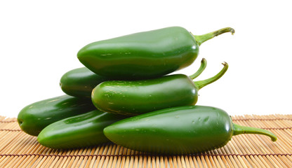 bunch of fresh green chili peppers on bamboo background