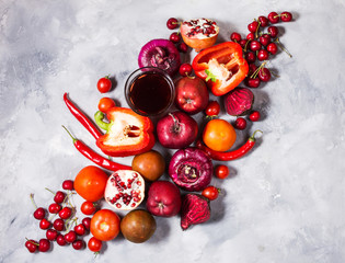 Raw red organic vegetables with fresh ingredients for healthily cooking on concrete background, top view.