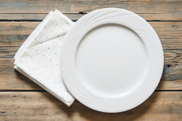green polka dot towel and empty white plate. Top view with copy space.
