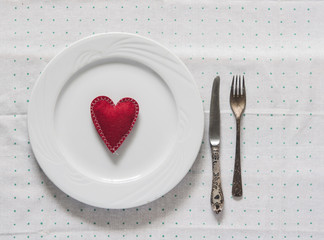 White empty plate with fork and knife on a polka dot tablecloth