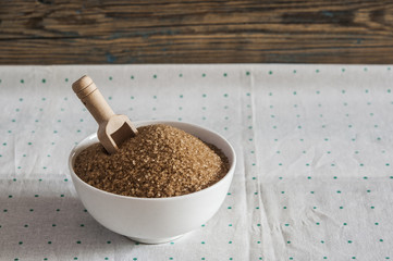Brown sugar in white ceramic bowl on the table
