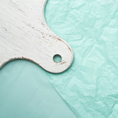 White kitchen board on a turquoise background