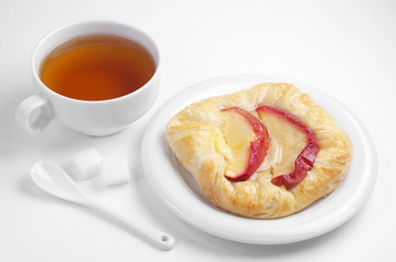 Bun with apples and cup of tea