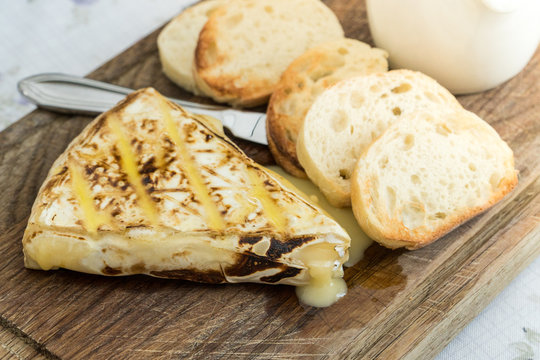 Slice of grilled camembert  with toasted baguettes