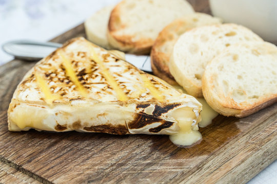 Slice of grilled camembert  with toasted baguettes
