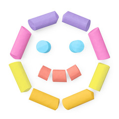 Colored sidewalk or blackboard chalks assembled like face happy emoticon on rough blackboard, 3D rendered