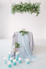 Wedding. Banquet. The chairs and table for guests, decorated with candles, served with cutlery and crockery and covered with a tablecloth.