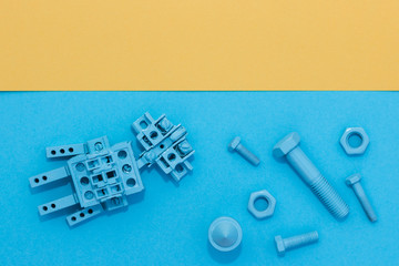 Metal robot, screws and washers, spring, colored with multicolored paint. Colorful background....