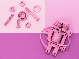Metal robot, screws and washers, spring, colored with multicolored paint. Colorful background....
