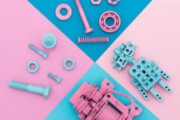 Metal robot, screws and washers, spring, colored with multicolored paint. Colorful background. Pink, blue, yellow. Concept, background, flat lay. Robotics, technology, AI concept.