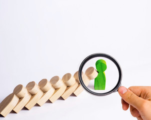 Fototapeta premium People in line fall like dominoes. Green man stops the fall of people as dominoes. The concept of durability and strength, business ideas. Willpower, strong nerves, strong character. Stubbornness.