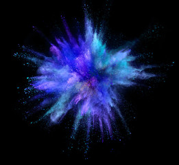 Explosion of coloured powder isolated on black background. Freeze motion of abstract colors shape...