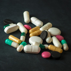 Pills on a black leather background