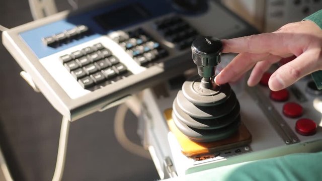 Clip pack of man hands control joysticks at grain terminal operator cabin workplace. Worker controlling loading grain from silo to bulker ship via moving trunk machine in dock.
