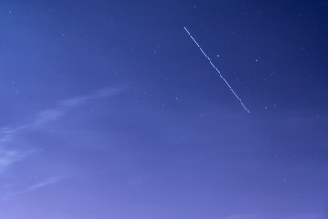 Obraz na płótnie Canvas International Space Station ISS trail crossing sky with stars and thin clouds