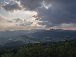 Obraz na płótnie Canvas Lusatian Mountains (luzicke hory) panorama,view from Hochwald (Hvozd) mountain on czech german borders with sun rays blue green hills forest and pink cloudy sunset sky background