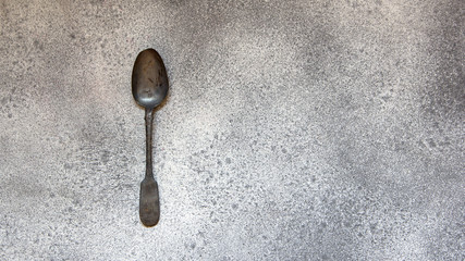Antique silver spoon on gray concrete style.