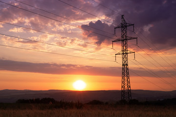 Sunset behind electricity pylon - obrazy, fototapety, plakaty