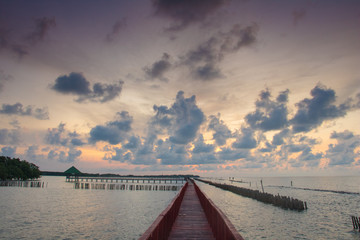 The red bridge and sun up in cloud blue sky back ground. bridge cross sea.Thailand landscape .