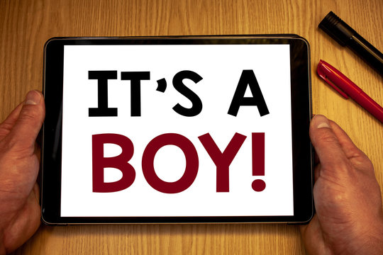 Text sign showing It S A Boy Motivational Call. Conceptual photos Male baby is coming Gender reveal CelebrationMan hold holding table with ideas words white screen black red pens wooden.