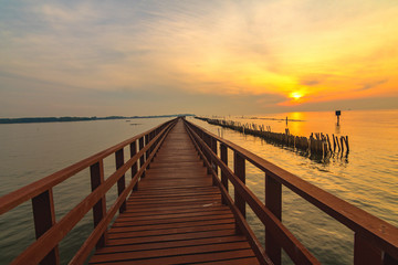 Fototapeta na wymiar In the morning The red bridge and sun up on horizon. bridge cross sea in Thailand .Thailand landscape .