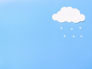 Paper clouds from which the paper hearts fall.