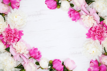 White and pink peonies on white wooden background. Holiday background, copy space, top view.