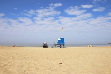 Fototapeta na wymiar Lifeguard tower and car on the beach. Lifeguard cabin on Baltic sea beach in Lithuania.