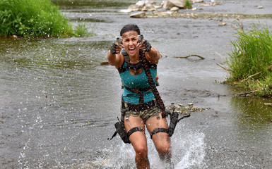 A young girl gets dressed up as a combat fighting woman.  She poses outdoors and makes good...