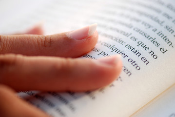 Obraz premium MUJER LEYENDO UN LIBRO. DETALLE MANO Y LIBRO