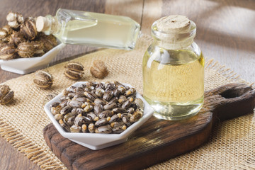 seeds and castor oil on the wooden table - Ricinus communis