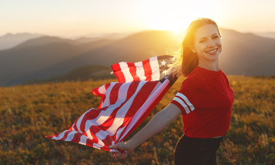 happy woman with flag of united states enjoying the sunset on nature