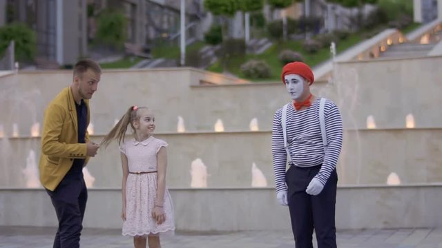 Mime and magician fighting for the girl's attention showing her their skills