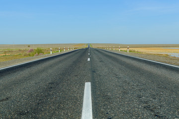 The picturesque landscape and blue sky over road. Asphalt road with marking