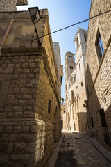 Fototapeta na wymiar A narrow alley in Giovinazzo old town, with the Cathedral on the right, Apulia, Italy
