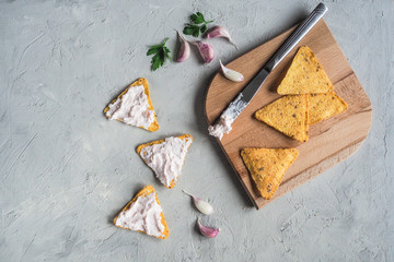 Snack with garlic cream and nachos chips on a gray cement background.