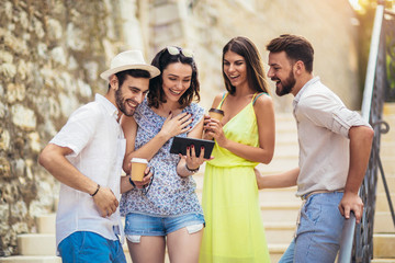 Group of young tourist friends with digital tablet having fun