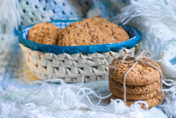 homemade oat cookies with sunflower seeds in and near blue checkered basket on white and blue plaid
