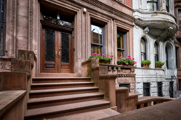 Fototapeta na wymiar a row of brownstone buildings and stoops in an iconic neighborhood of Manhattan, New York City