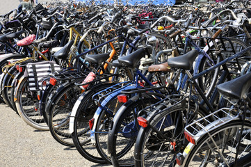 many different bikes are parked in the city center of Amsterdam for hire by tourists