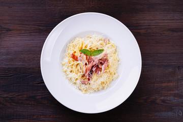 Pasta carbonara with ham, parmesan and creamy sauce, traditional Italian recipe. Family restaurant, Italian menu