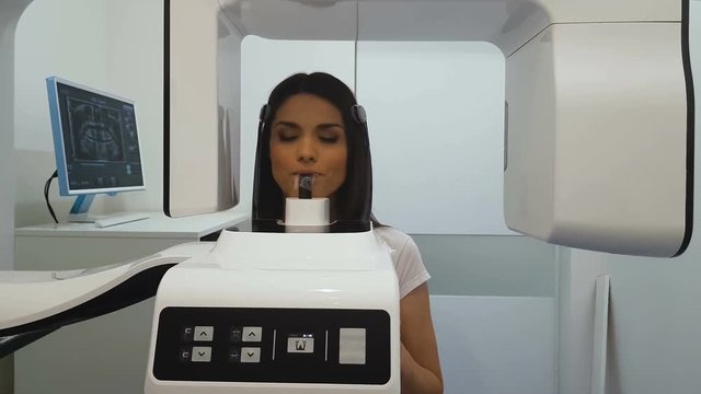 Woman undergoing panoramic x-ray exam, professional radiographic equipment