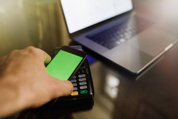 Close up of a card payment being made betweem a man and a waiter in a cafe.